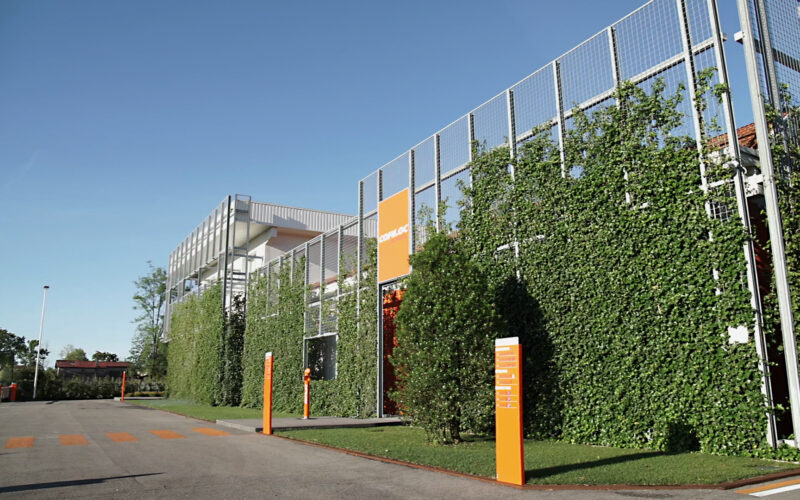 spazio verde aziendale con prato, parete verde verticale e aiuole